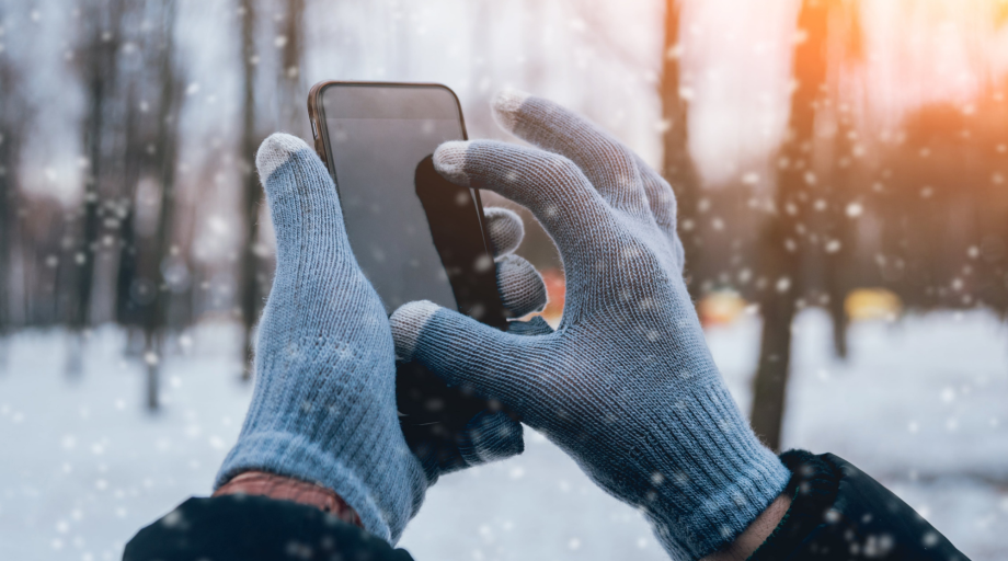 Montis blog dłonie w rękawiczkach trzymają zimą smartfon